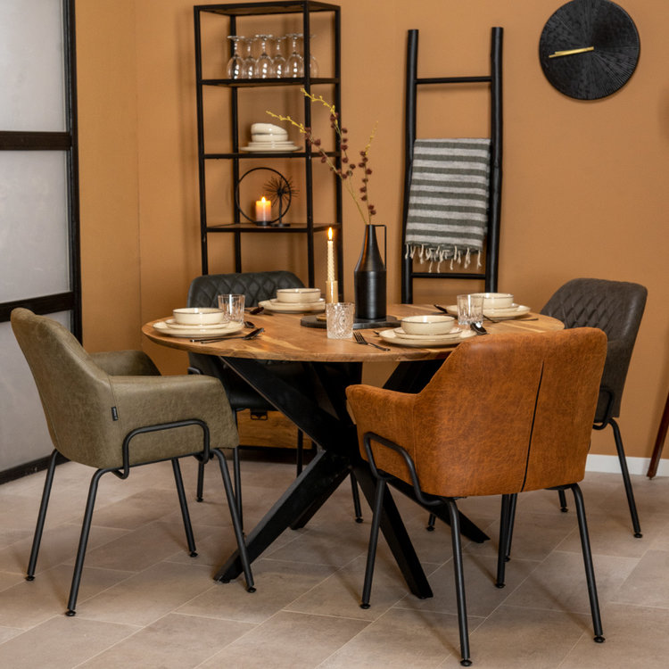 Une salle à manger scandinave avec une table en bois brut et des fauteuils en cuir