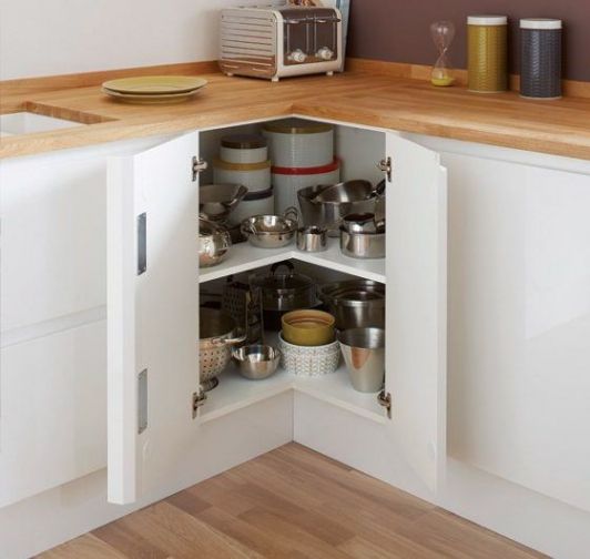 Un meuble d'angle optimise l'espace de cette cuisine en L, lumineuse en blanc et bois
