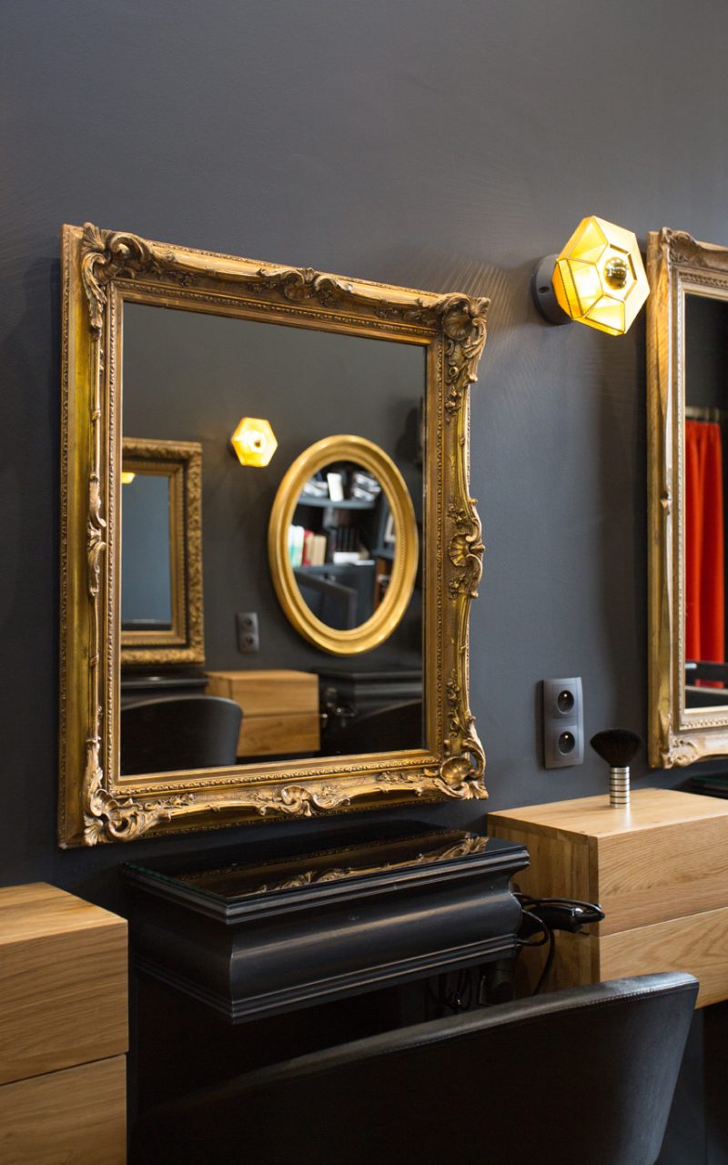 Un miroir élégant pour la déco salon de coiffure, avec un cadre en bois doré et ouvragé