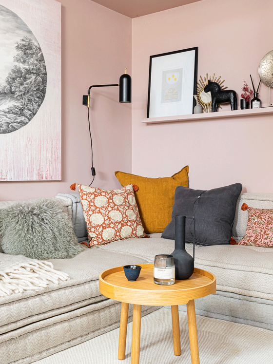Un petit salon rose mis en valeur par les meubles design et la luminosité