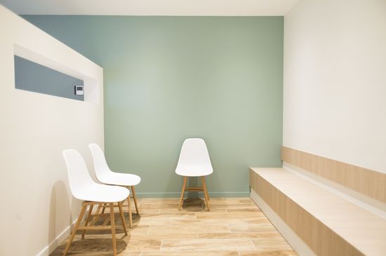 La décoration cabinet médical est dans les tons pastel, de style scandinave, avec un mur vert pâle