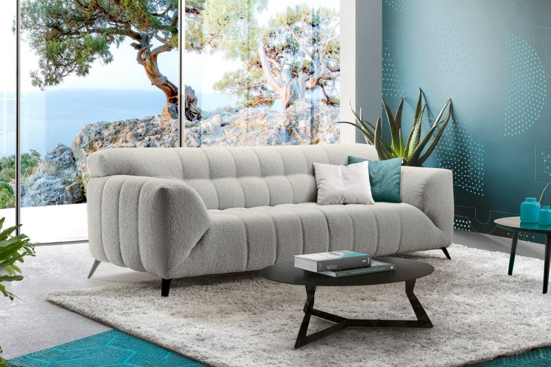 Des meubles tendances subliment le salon, avec un canapé capitonné et une table basse design
