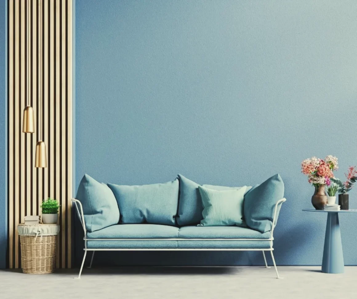 Pièce de vie à la déco minimaliste, avec le mur et le canapé bleus
