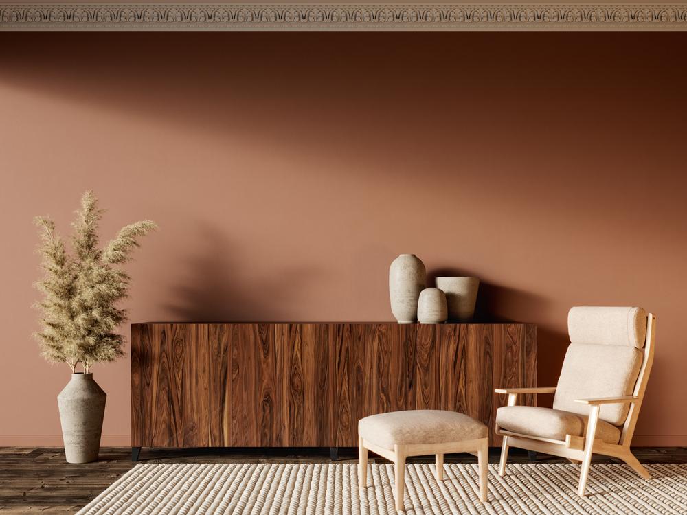 Un grand mur terracotta réchauffe la pièce, avec un meuble en bois massif