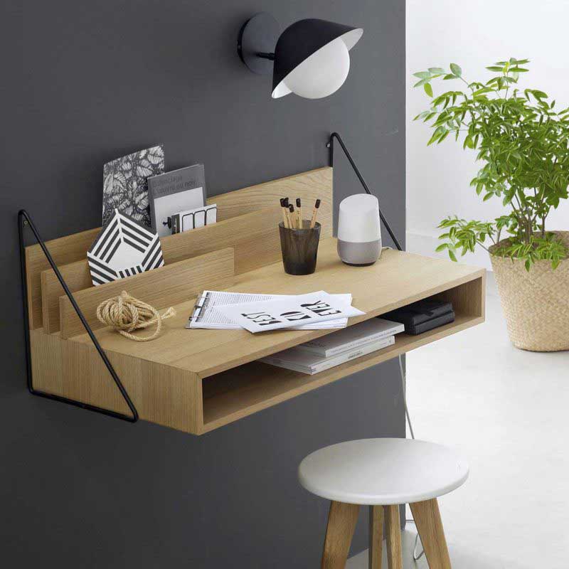un bureau en bois design suspendu au mur gris