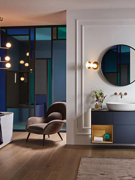 Une déco salle de bains 2024 avec des couleurs profondes, du parquet au sol, une baignoire design avec un robinet chromé, et un meuble vasque suspendu