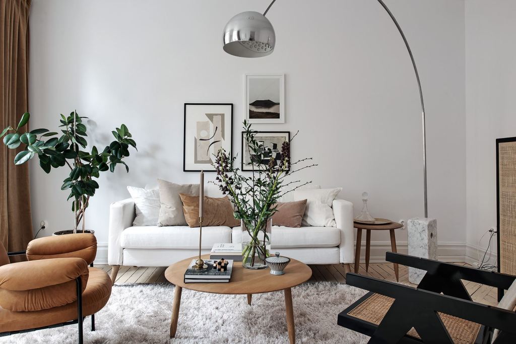 Une déco salon moderne chic qui inclut un grand lampadaire argenté courbé au-dessus du canapé
