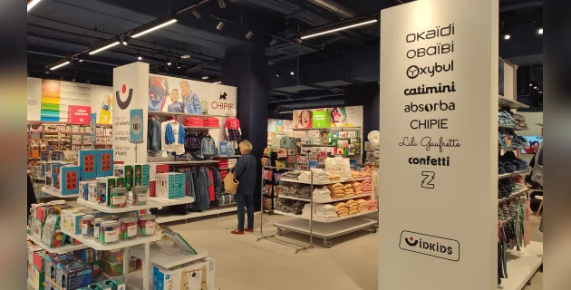 Un magasin de vêtements pour enfant, avec des panneaux bien en vu qui indiquent clairement les prix
