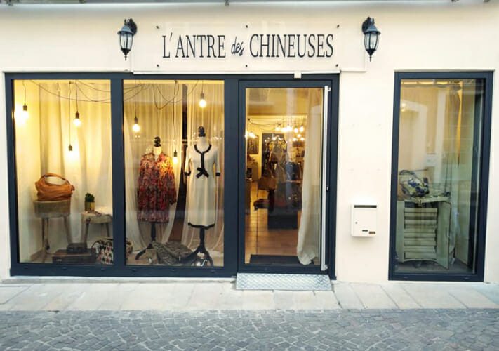 Un agencement boutique avec une vitrine attrayante, des vêtements mis en valeur par des ampoules suspendues