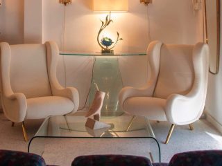 deux fauteuils style mid century dans un salon moderne avec appliques murales en laiton