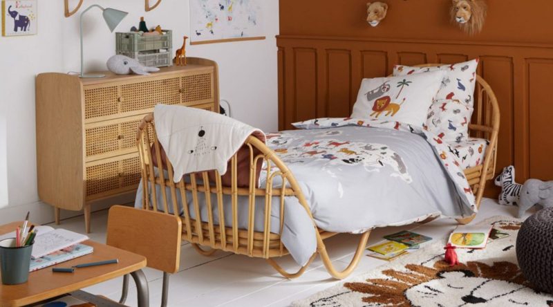 lit enfant vintage en rotin et meuble de rangement en osier dans une chambre couleur terracotta