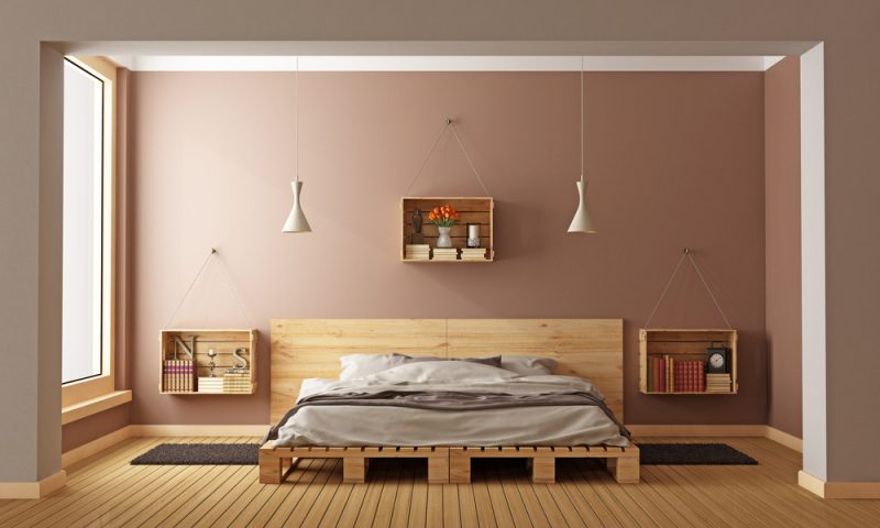 chambre avec lit en palettes et tête de lit avec rangements sur parquet en bois
