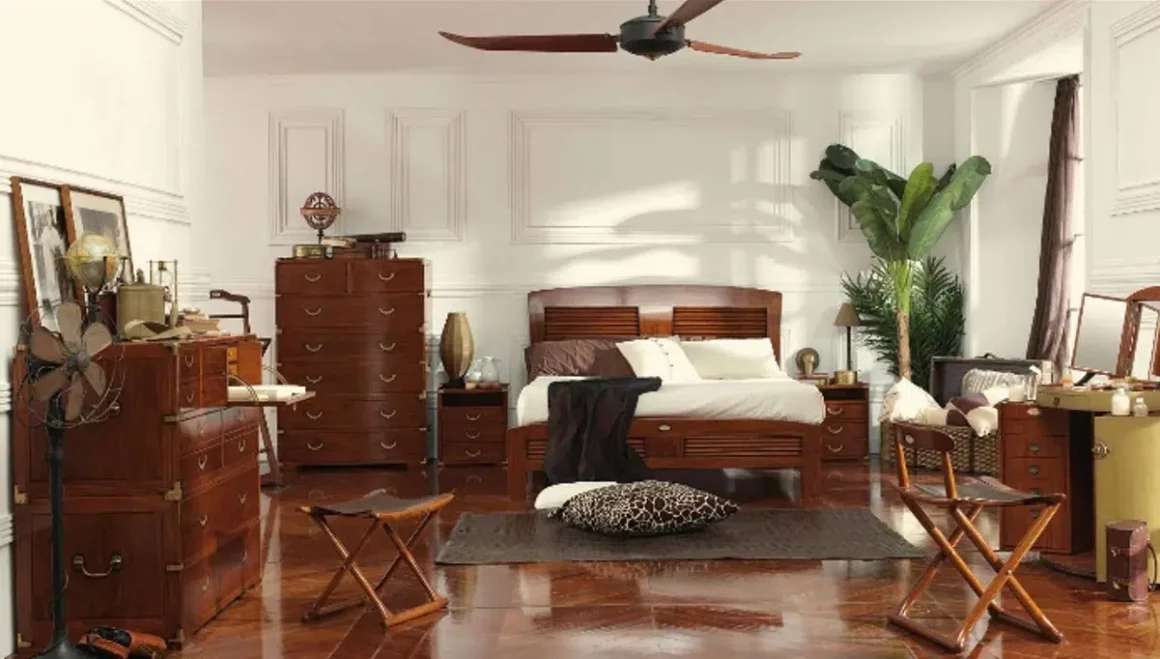 Les meubles de la chambre sont en bois foncé, et la pièce se pare d'une imposante plante verte