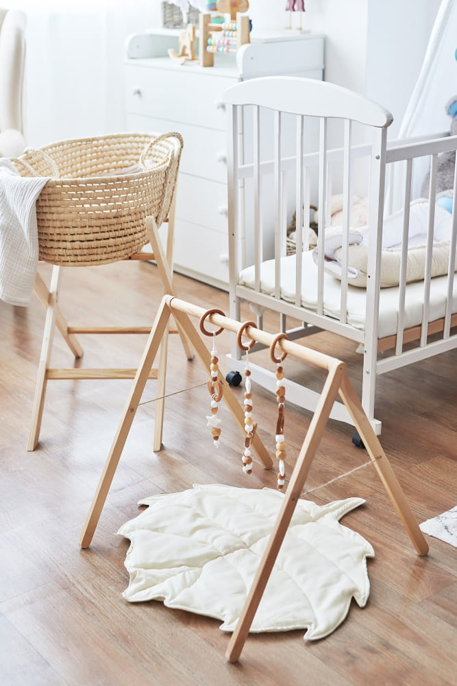 Du mobilier chambre bébé en bois, avec une arche d'activités de style scandinave
