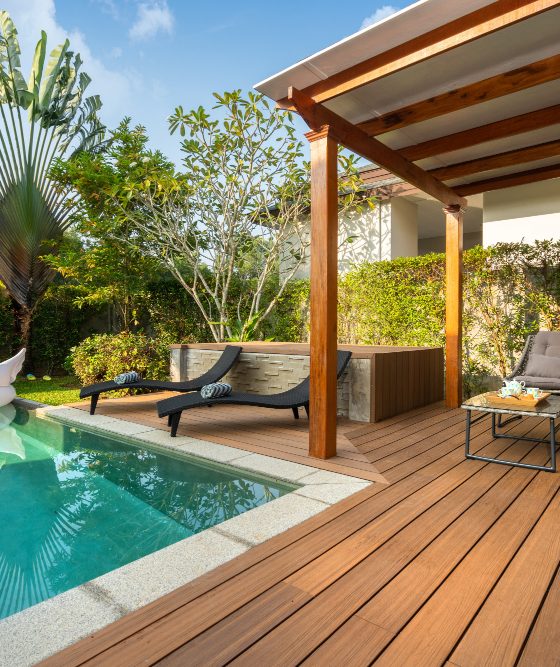 Une déco terrasse piscine en bois avec un pool house et des meubles tendance