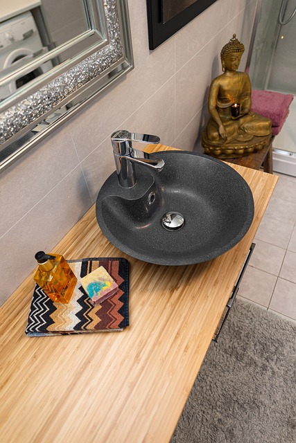 un lavabo en granite noir sur un meuble en bois pour une salle de bain tendance