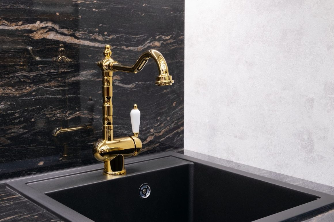 un robinet dorée chic et vintage dans une cuisine avec un plan de travail en marbre noir