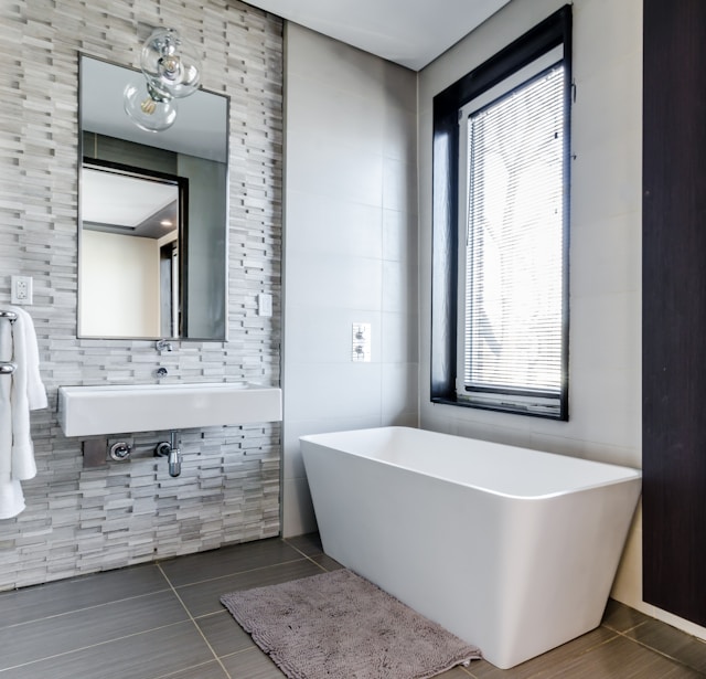 une idée déco pour une salle de bain moderne et lumineuse avec un mur en pierre et une baignoire 