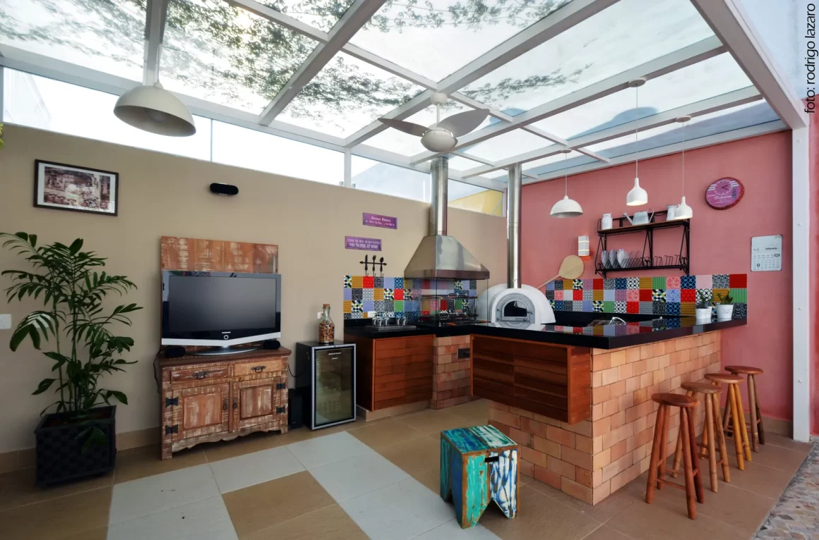 Une cuisine extérieure avec un toit en verre, un coin barbecue et une belle déco moderne