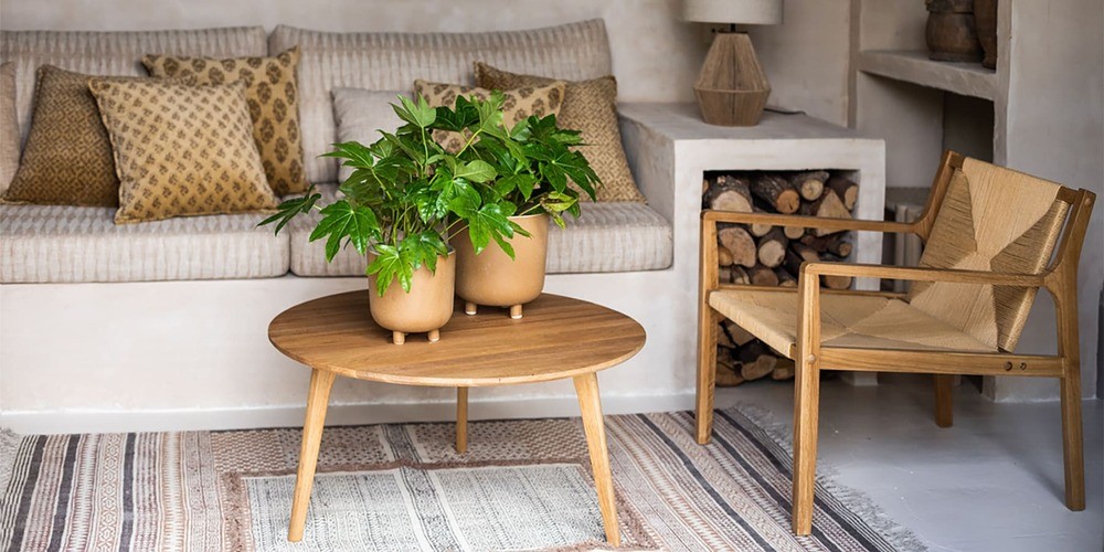 espace extérieur avec une table basse ronde en bois style scandinave et au dessus des plantes en pots et à coté d'une chaise en bois