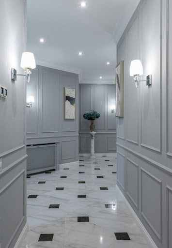 Un couloir élégant avec des murs gris et un sol en marbre.