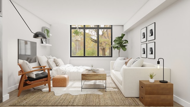 Un salon moderne avec un canapé blanc, un fauteuil gris, une table basse en bois et une télévision accrochée au mur.