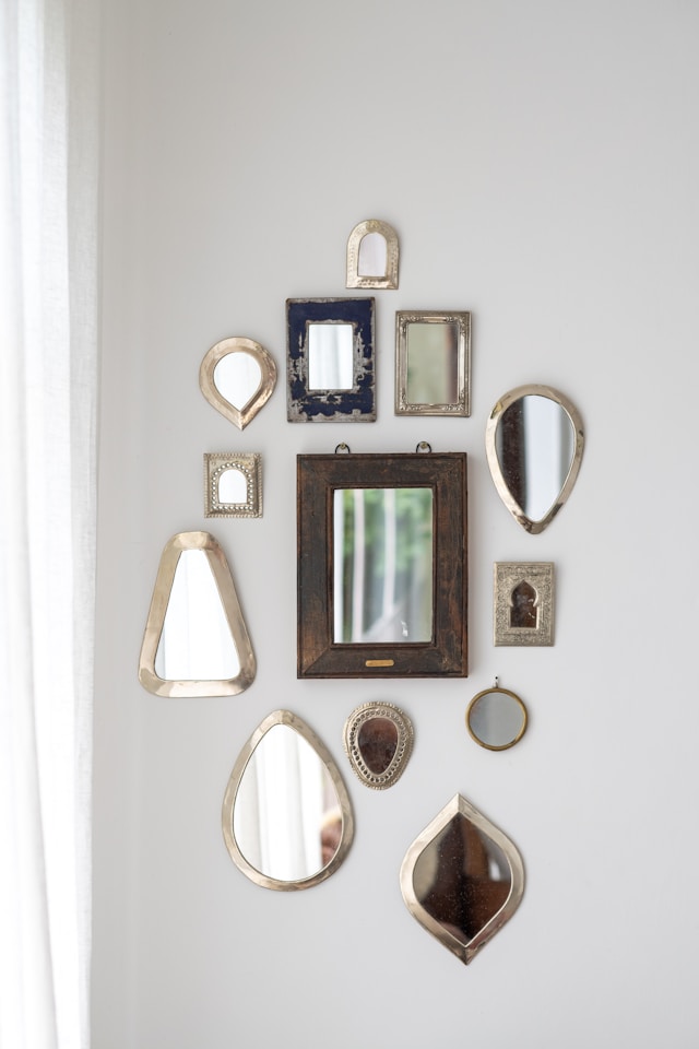 Miroirs rectangulaires disposés en damier sur un mur.