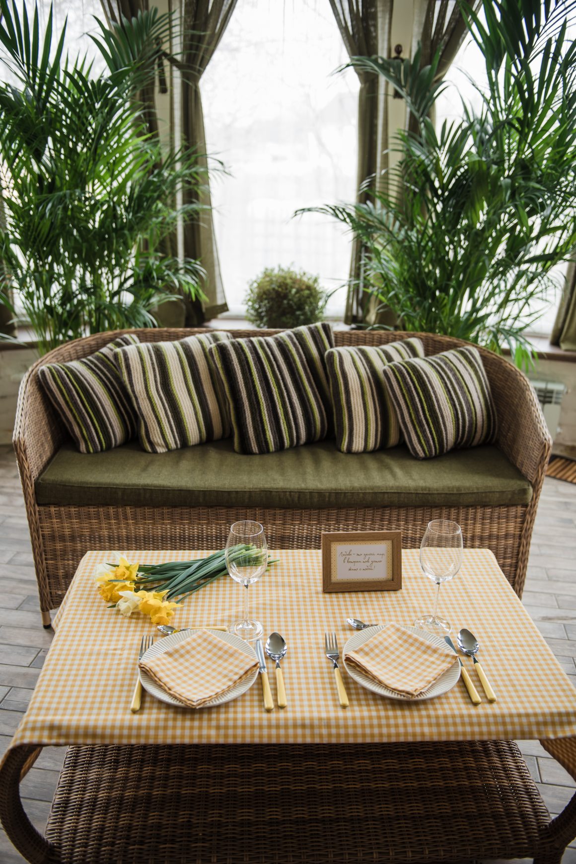 une table en rotin entourée de plantes luxuriantes, illustrant une décoration tropicale