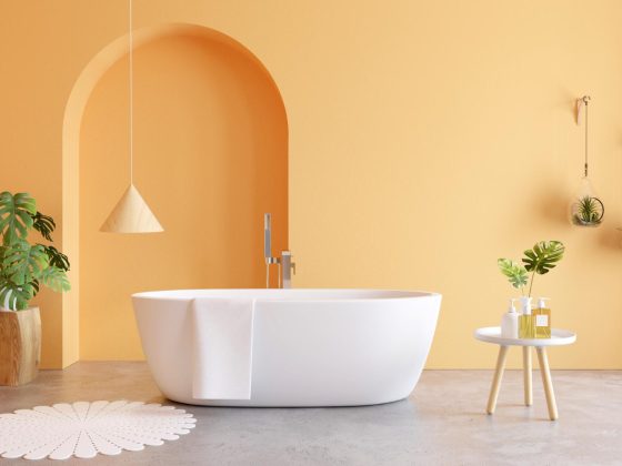 Une salle de bains moderne, avec baignoire, aux murs revêtus d'une couleur tendance, l'abricot