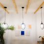 Trois luminaires tendance 2025 suspendus au plafond, en forme d'anneaux noirs très lumineux