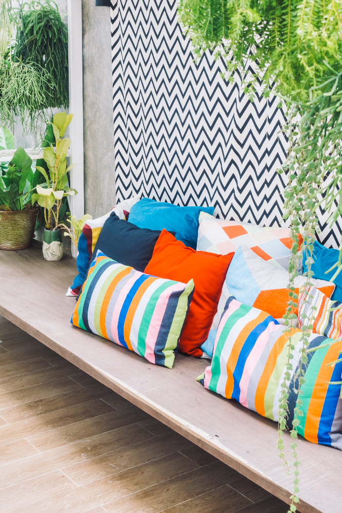 un banc avec de nombreux coussins très colorés