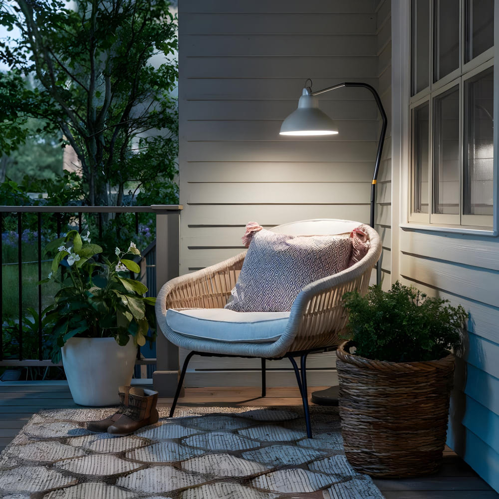 Une lampe sur pied au-dessus d'un fauteuil, sur un confortable balcon avec tapis