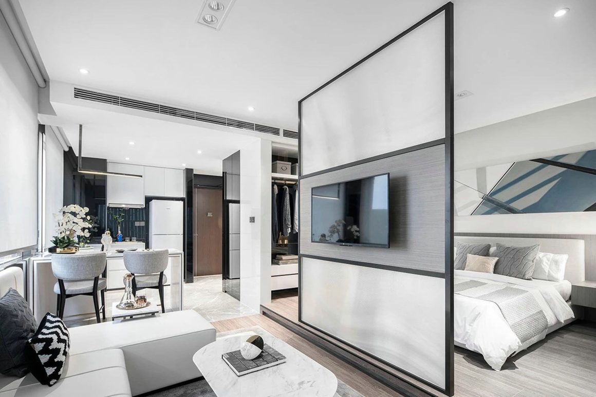 Un espace moderne et élégant, avec un coin salon, une cuisine ouverte et une chambre bien séparée avec un panneau coulissant.