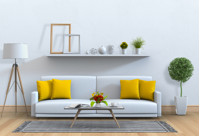 un salon minimaliste avec un canapé blanc, des coussins jaunes, une table basse, un lampadaire et une décoration élégante.