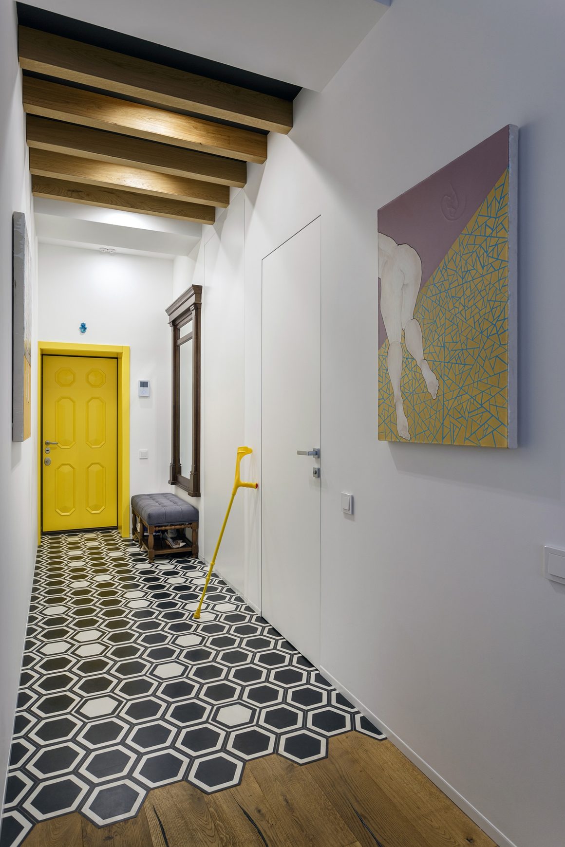 peinture couloir étroit avec des murs blancs, décorations artistiques et un sol géométrique.