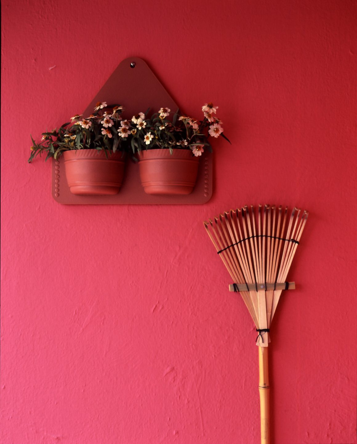 déco petit balcon avec des pots de fleurs aux teintes douces sur un fond rose, créant une atmosphère chaleureuse et accueillante.