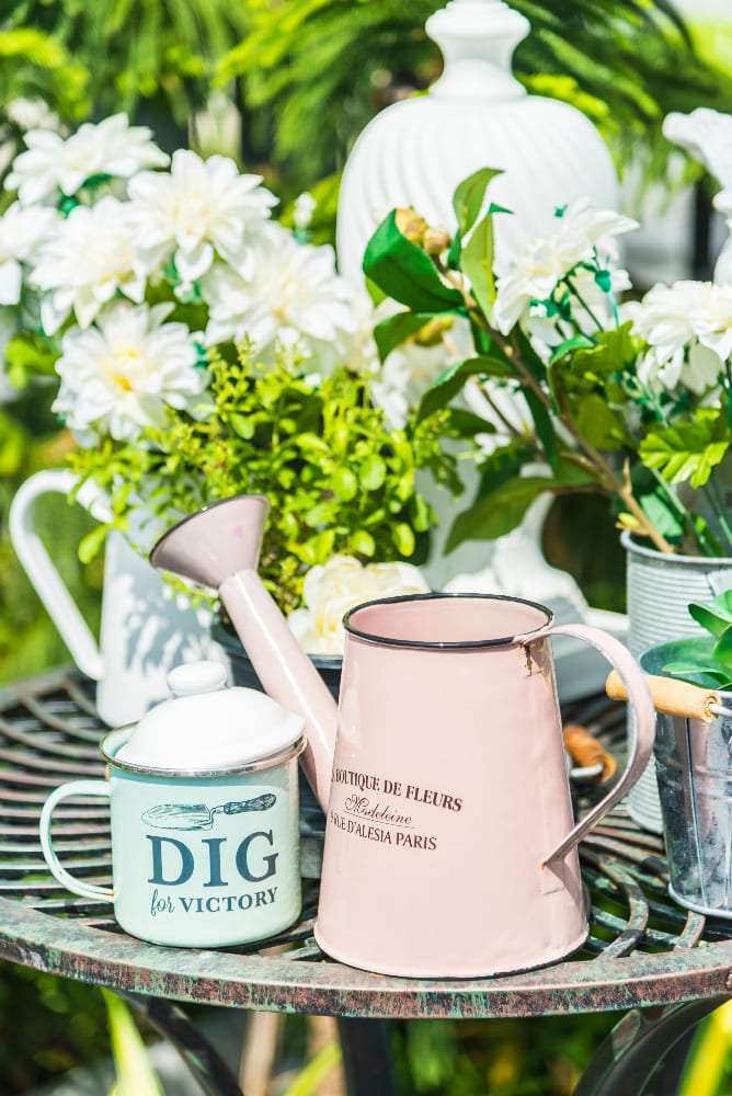 des tasses et des arrosoirs de jardin sur la table extérieure