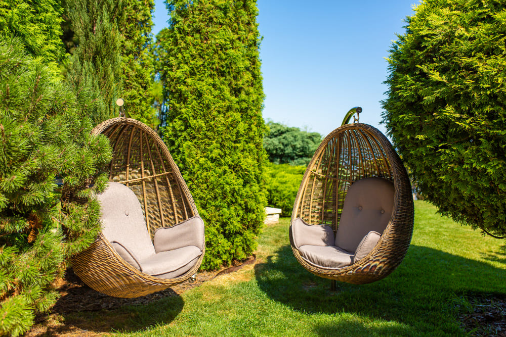 deux fauteuils osier en forme d’œufs dans le jardin
