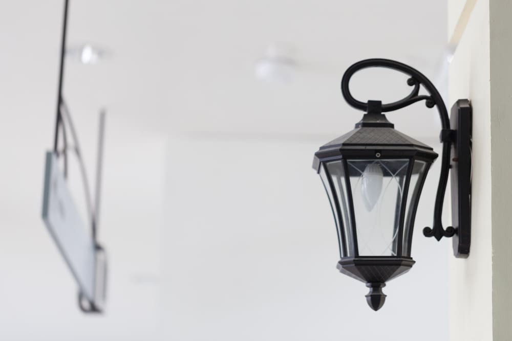 une lanterne noire tendance accrochée au mur de la terrasse