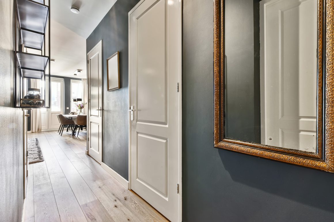 Un couloir étroit et haut peint en bleu marine apporte beaucoup de sérénité, avec des portes blanches pour un contraste élégant.