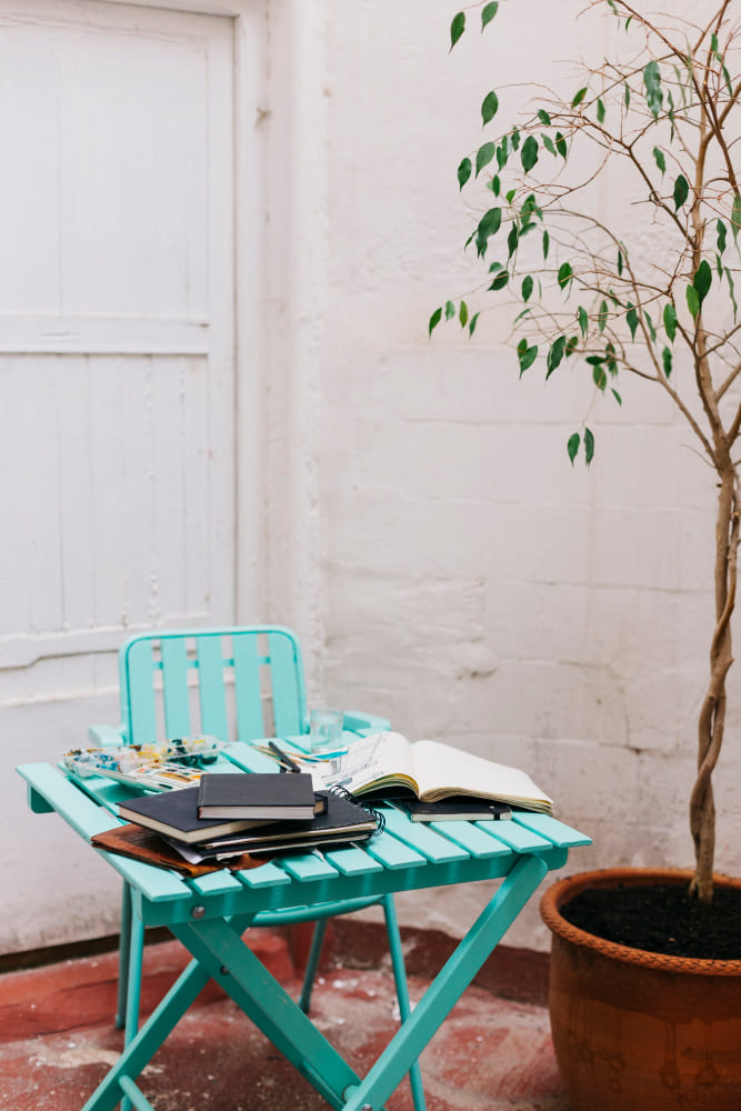 une petite chaise et une petite table extérieures de couleur bleu turquoise