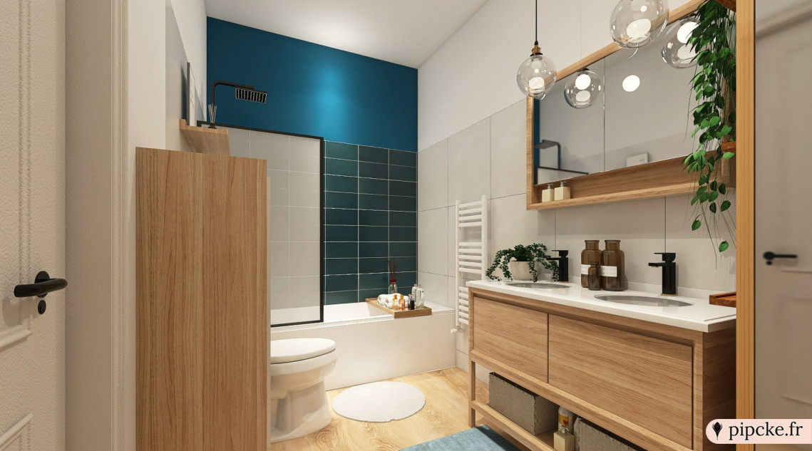 une salle de bain avec des murs clair, un accent bleu, une baignoire avec un pare-douche, un lavabo sur meuble en bois, un miroir, des luminaires suspendus et des plantes décoratives.