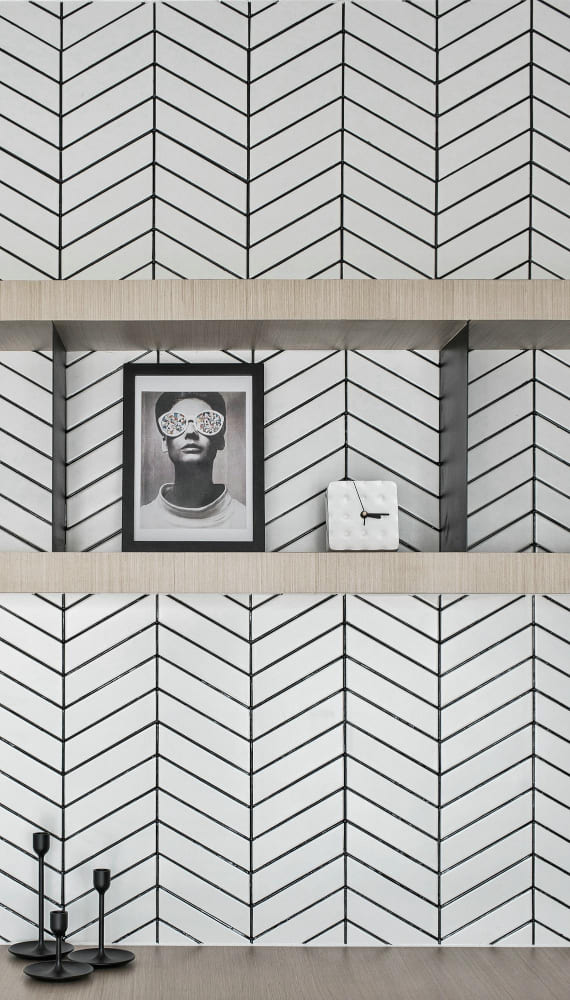 Une tapisserie aux motifs géométriques noir et blanc, avec des étagères en bois