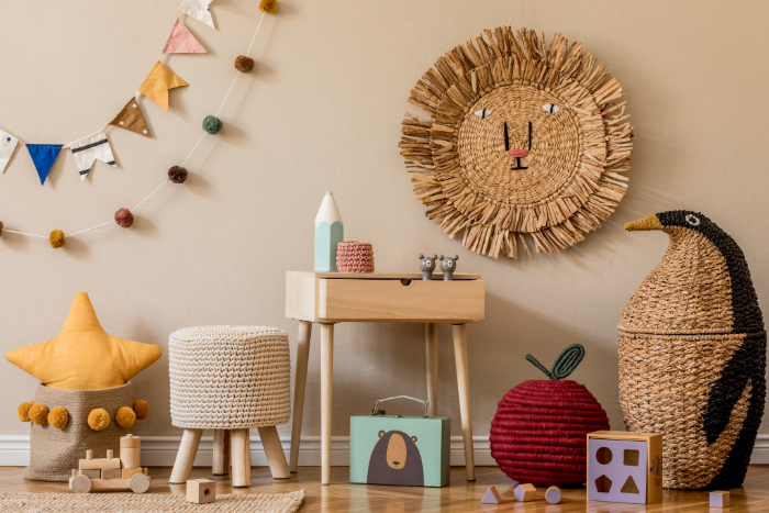 Décoration ludique et naturelle pour chambre bébé thème jungle avec paniers animaux, guirlande colorée, jouets en bois et éléments en rotin tressé.