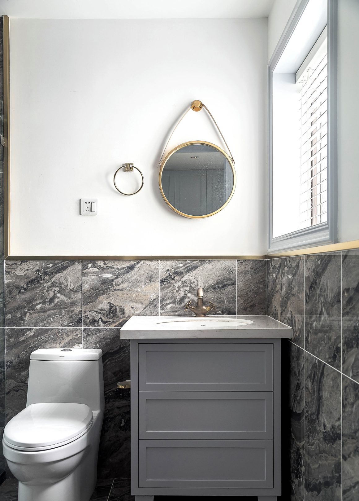 toilettes sousbassement en marbre gris, murs teintes claires, ambiance elegante et fonctionnelle