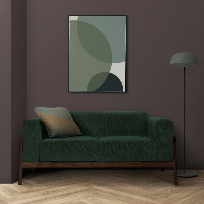 Un salon moderne avec un canapé vert, un tableau abstrait et un lampadaire élégant.