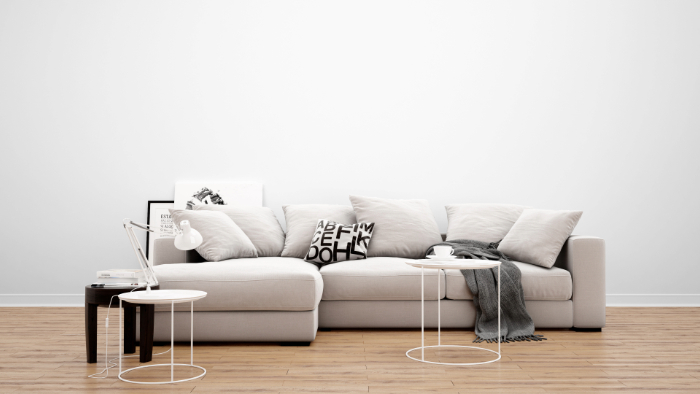 Salon incluant un canapé confortable avec housse blanche, coussins doux, tables basses modernes et lampe.