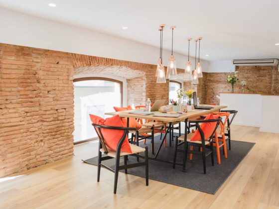 Une rénovation appartement ancien réalisée avec beaucoup de goût, dans cette grande pièce salle à manger, avec des murs en briques