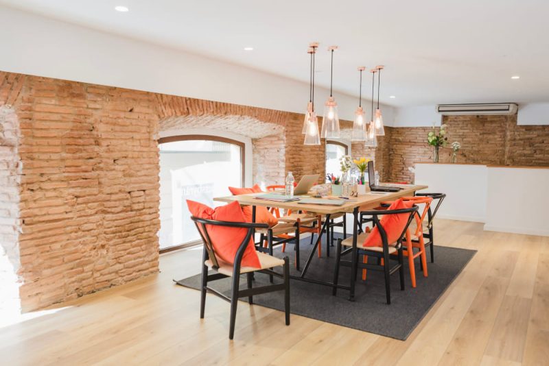Une rénovation appartement ancien réalisée avec beaucoup de goût, dans cette grande pièce salle à manger, avec des murs en briques