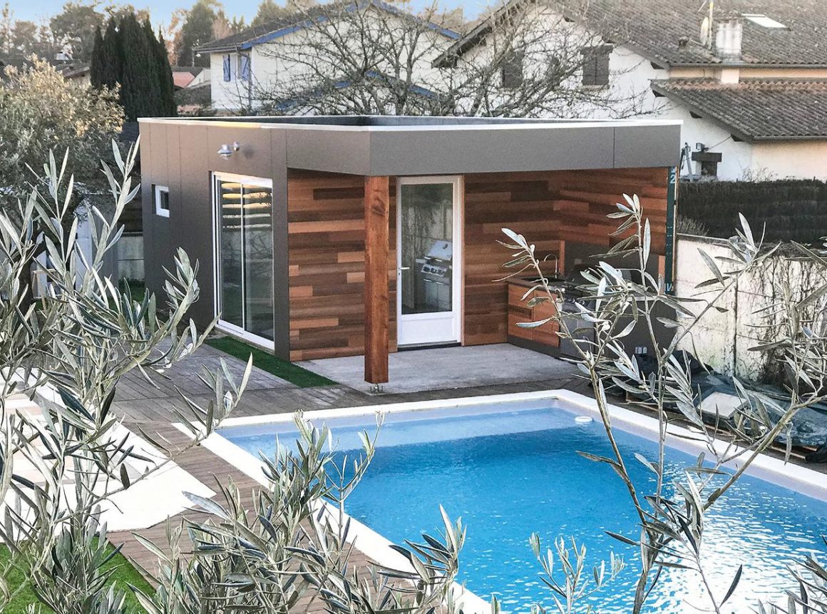 Pool house design avec terrasse aménagée et cuisine extérieure